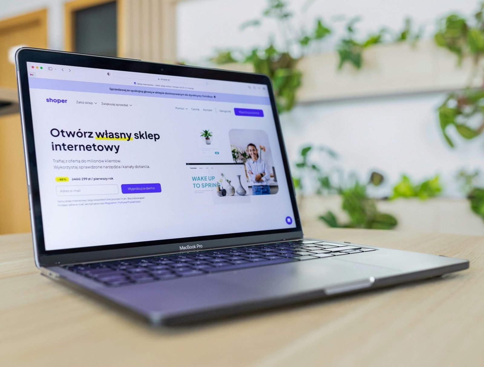 Close-up of a laptop with an open e-commerce website, surrounded by modern office decor.